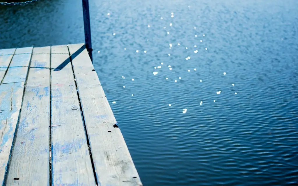 Muskoka chairs on a dock at a lake