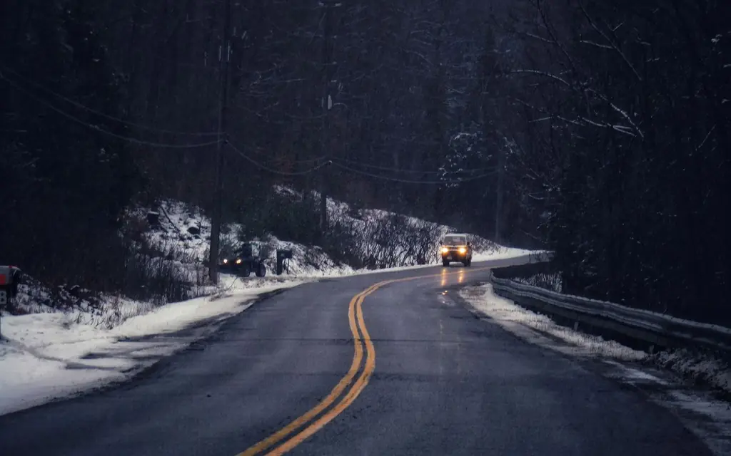 A car on a snowy road at dusk