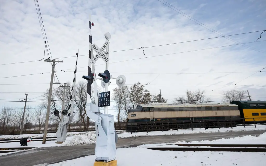 A passenger train at a snowy level crossing