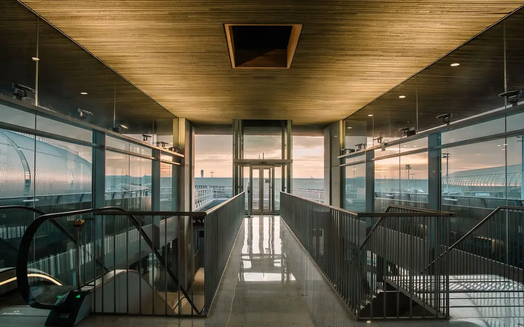 Glass-walled airport terminal walkway at dusk